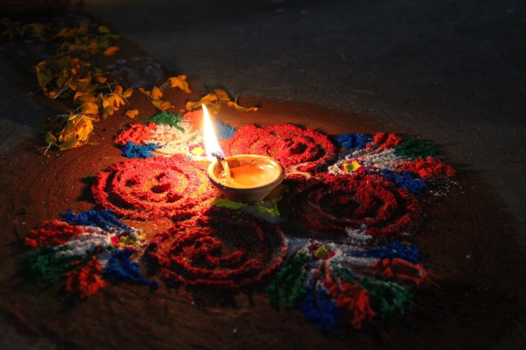 tihar-festival-in-nepal-min A vibrant Rangoli design lit by a glowing diya at its center celebrates the beauty, light, and traditions of Tihar.