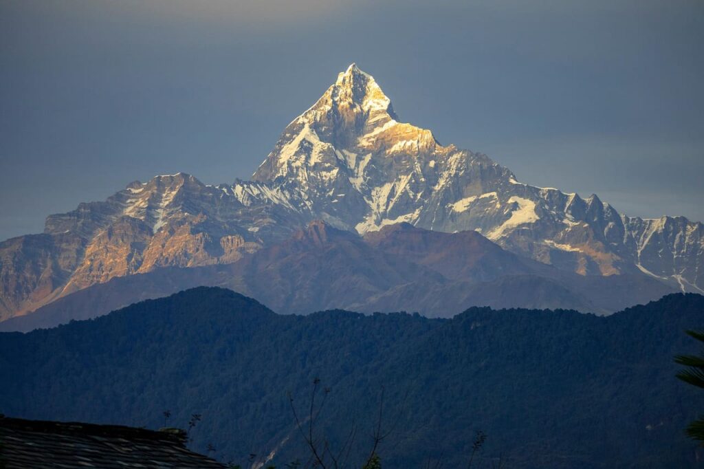 Beautiful sunrise casting golden light over the Machapuchhare mountain peaks in the Himalayas.