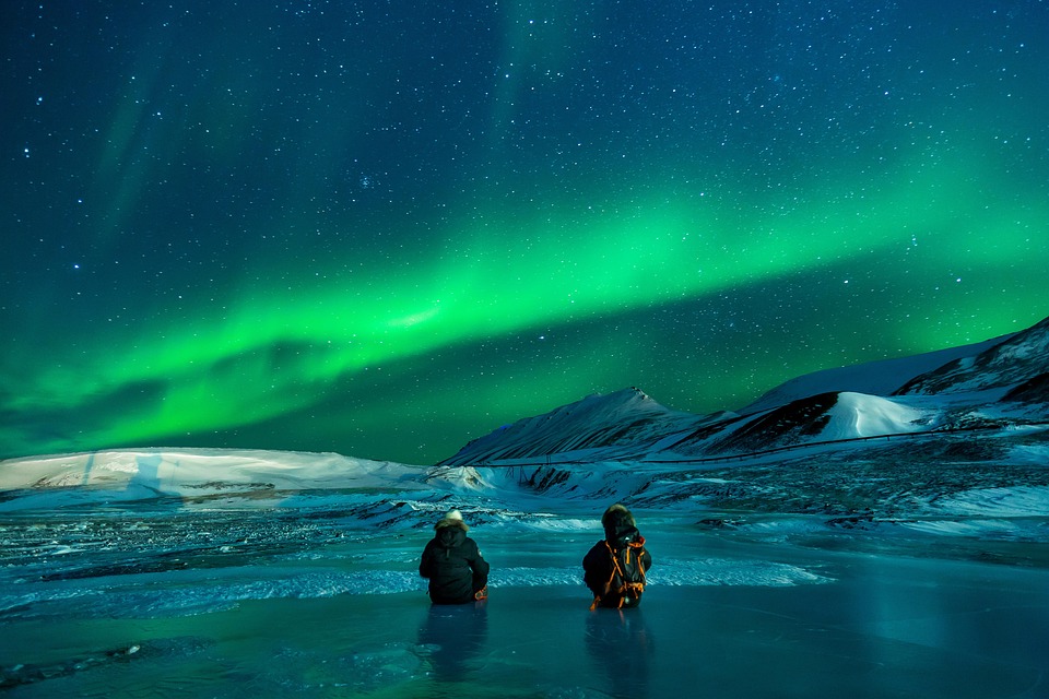 aurora-northern-lights Northern Lights aurora borealis glowing in the night sky above a snowy landscape.
