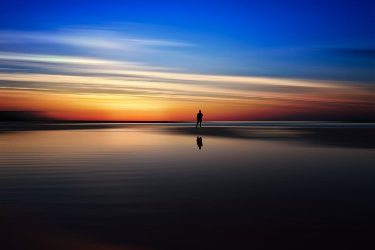 Stunning sunset over the calm sea in the Philippines with vibrant orange and pink hues reflecting on the water.