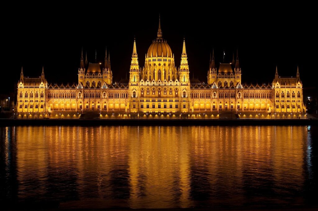 Panoramic view of Budapest, Hungary, featuring the Danube River, historic bridges, and the city’s iconic parliament building under a clear sky.