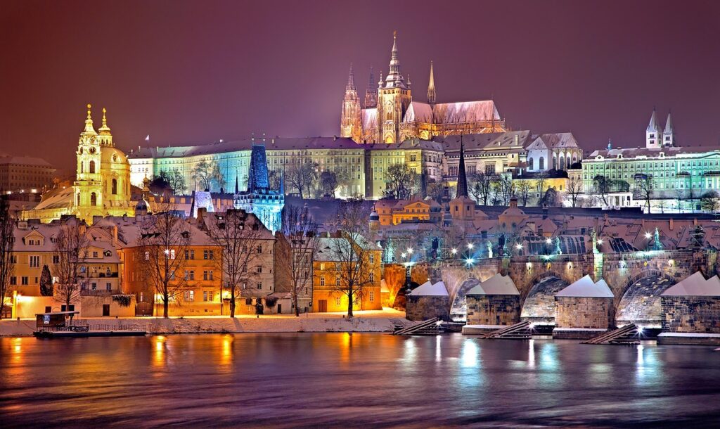 Historic cityscape of the Czech Republic, featuring charming old-town buildings, cobblestone streets, and a view of a medieval castle in the background.