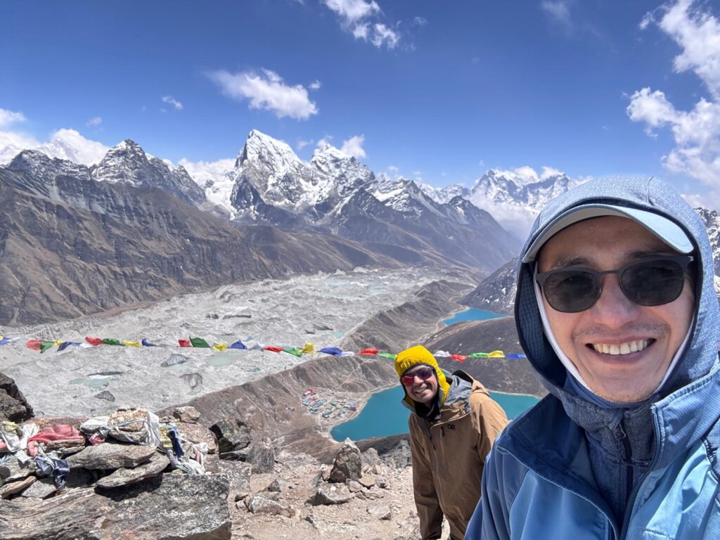 Trekkers stopping to take photos along the trail to Gokyo Lake with Himalayan mountains in the background.