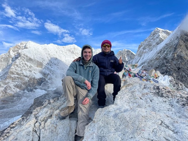 Trekkers enjoying panoramic mountain views during the Everest Three Pass Trek, surrounded by snow peaks and rugged Himalayan trails.