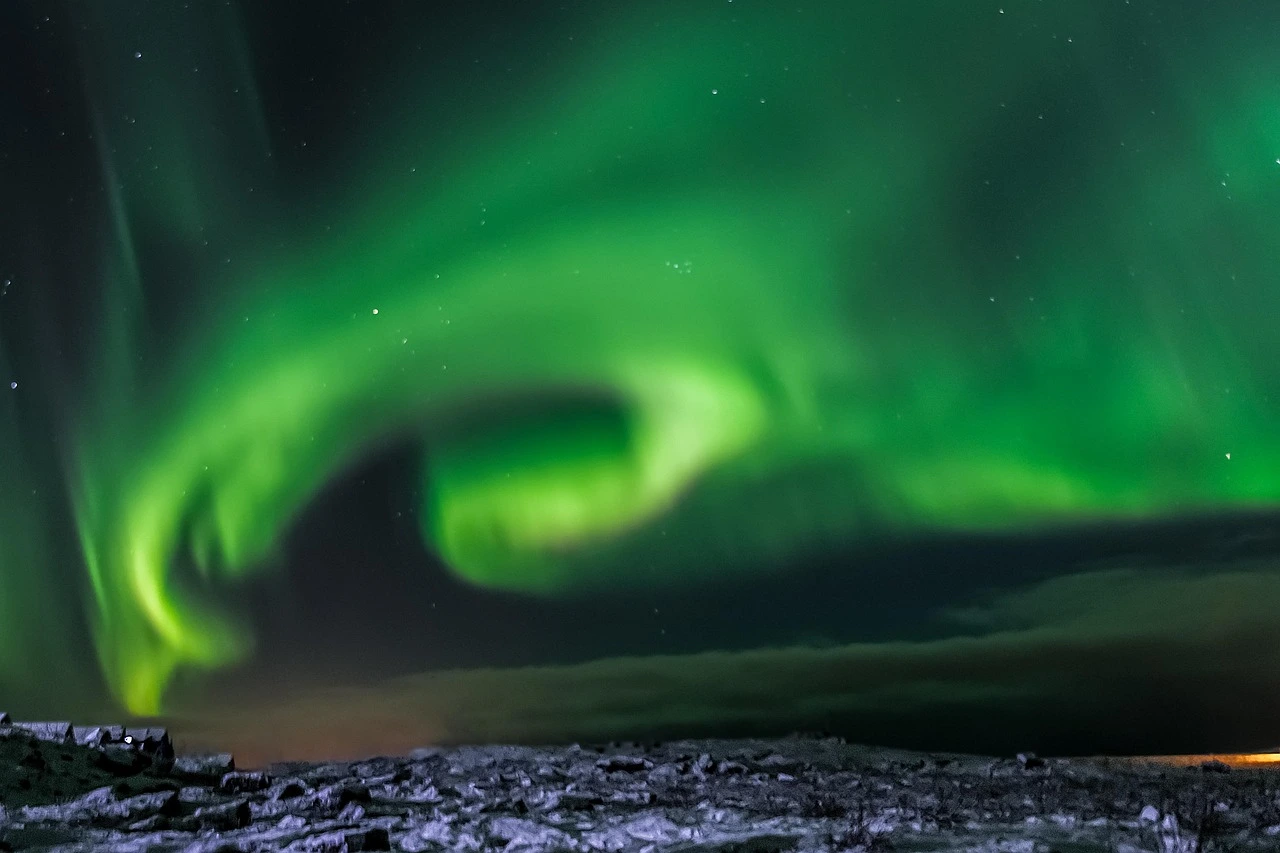 Northern Lights dancing over snowy mountains in Norway