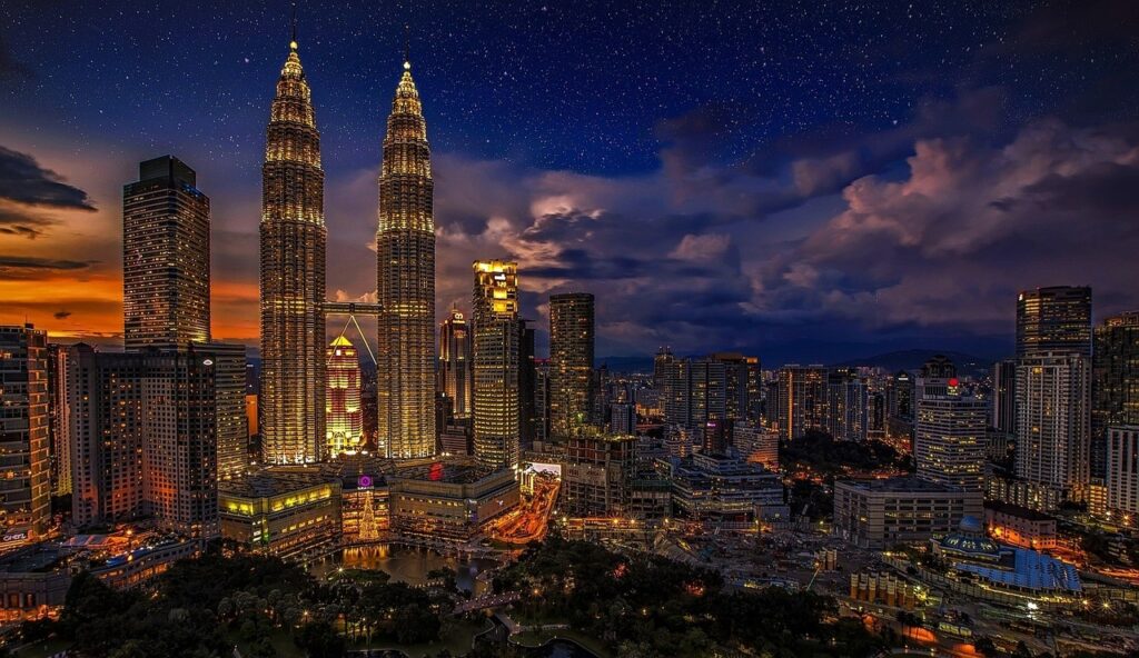 Modern skyscrapers of Malaysia reaching into a clear blue sky, showcasing the city’s urban skyline and architectural beauty.