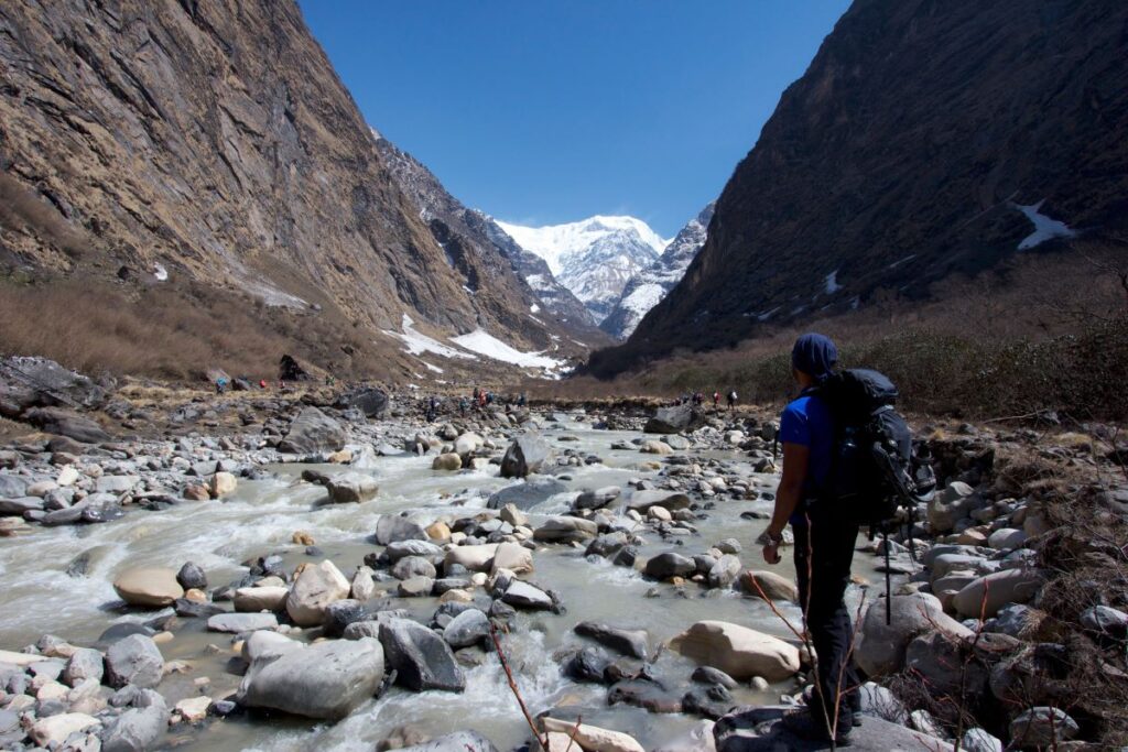 man walking on glacier river